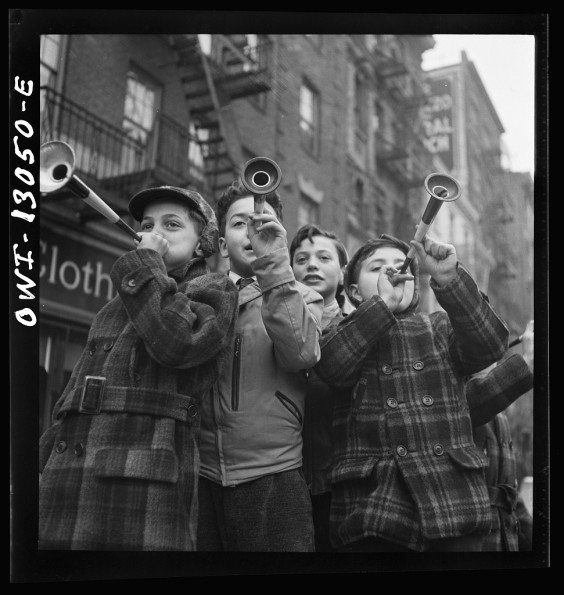New York, New York. Blowing horns on Bleeker Street on New Year's Day