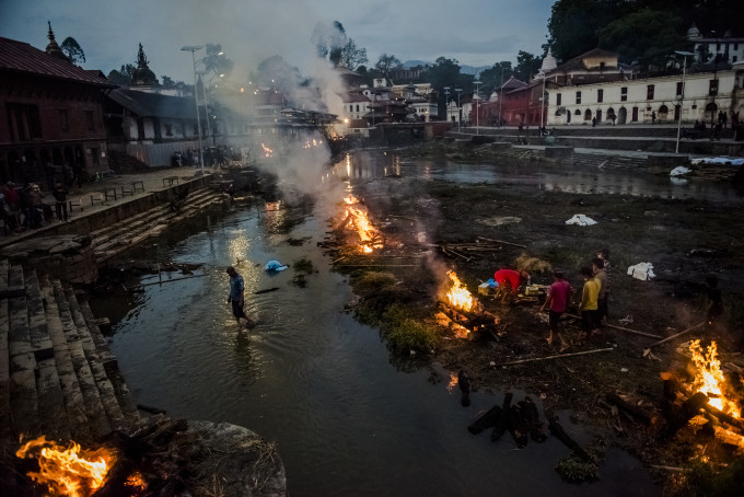 8—Kathmandu, Nepal, Tuesday, April 28, 2015: Flames rise from burning funeral pyres during the cremation of earthquake victims, at the Pashupatinath temple on the banks of Bagmati river on April 28, 2015 in Kathmandu, Nepal. On the 25th of April, just before noon local time, as farmers were out in fields and people at home or work, a devastating earthquake struck Nepal, killing over 8,000 people and injuring more than 21,000 according to the United Nations Office for the Coordination of Humanitarian Affairs. Homes, buildings and temples in Kathmandu were destroyed in the 7.8 magnitude quake, which left over 2.8 million people homeless, but it was the mountainous districts away from the capital that were the hardest hit. Villagers pulled the bodies of their loved ones from the rubble by hand and the wails of grieving families echoed through the mountains, as mothers were left to bury their own children. Over the following weeks and months, villagers picked through ruins desperate to recover whatever personal possessions they could find and salvage any building materials that could be reused. Despite relief teams arriving from all over the world in the days after the quake hit, thousands of residents living in remote hillside villages were left to fend for themselves, as rescuers struggled to reach all those affected. Multiple aftershocks, widespread damage and fear kept tourists away from the country known for its searing Himalayan peaks, damaging a vital climbing and trekking industry and compounding the recovery effort in the face of a disaster from which the people of Nepal continue to battle to recover.