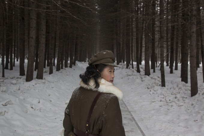 In this Wednesday, April 4, 2012 photo, a North Korean soldier, working as a guide, walks through a forest that is said to be a former camp site where the late North Korean leader Kim Il Sung overnight while leading a battle against the Japanese at the foot of Mount Paektu, North Korea.