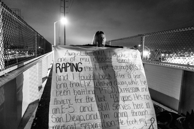Under cover of darkness, US Navy sailor Melissa Bania, holds a banner inscribed with the story of her rape before hanging it on the footbridge across from Naval Station San Diego. Military Sexual Trauma survivors gathered in San Diego to bring attention to the epidemic of rape in America’s military.