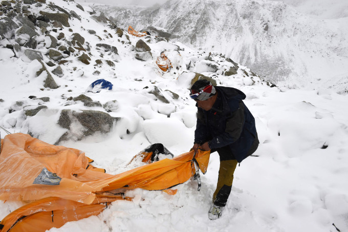 Trekking guide Pasang Sherpa searches for survivors among flattened tents moments after a wall of rock, snow and debris slammed on Everest base camp on April 25, 2015 killing at least 22 people. The avalanche was triggered by a powerful 7.8-magnitude earthquake that killed more than 8,000 people in the country. Rescue helicopters managed to reach the site about 18 hours after the avalanche as bad weather, aftershocks and fears of further avalanches rattled survivors. At the time of the disaster, the 5,364-meter-high Base Camp was teeming with hundreds of climbers and supporting teams who use the base to prepare their ascent to the peak of Mount Everest, the tallest mountain on Earth.