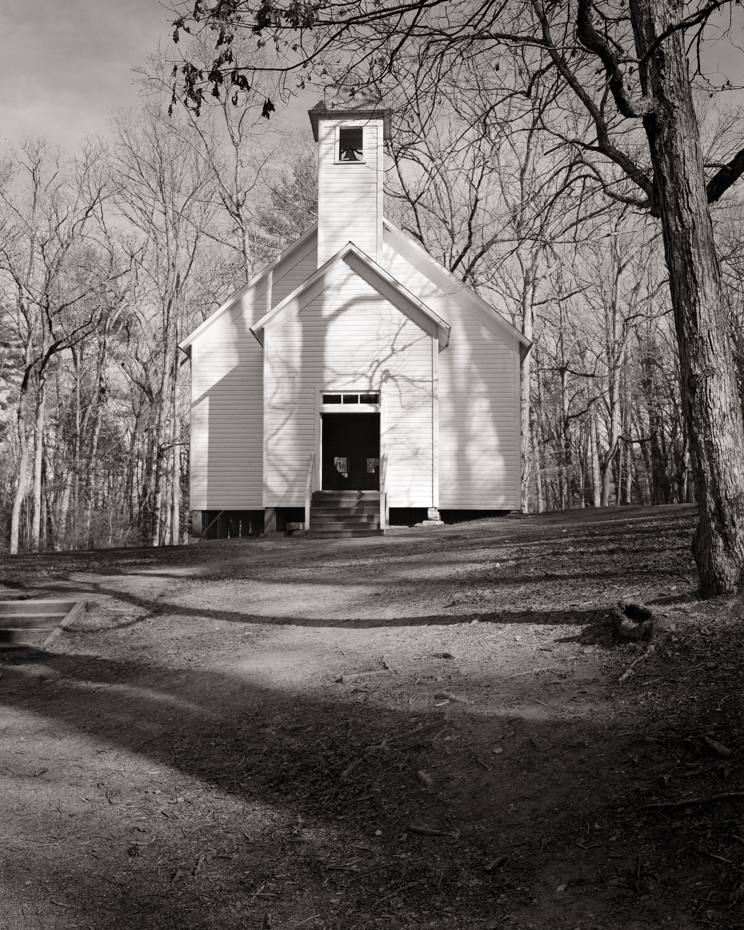 Shadows of the surrounding forest become one with a quaint old church in Cade's Cove.