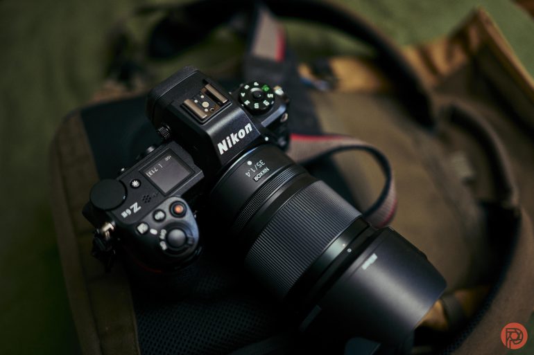 A Nikon Z6 camera with a lens, placed on a brown camera bag.