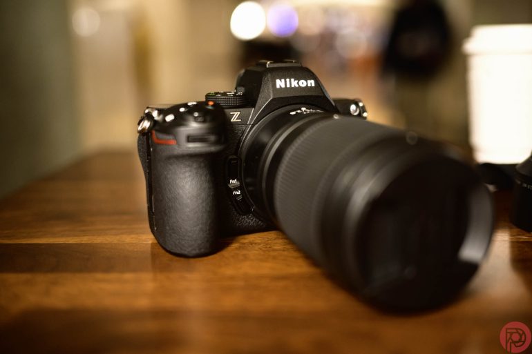 A Nikon Z series camera with a zoom lens on a wooden surface.