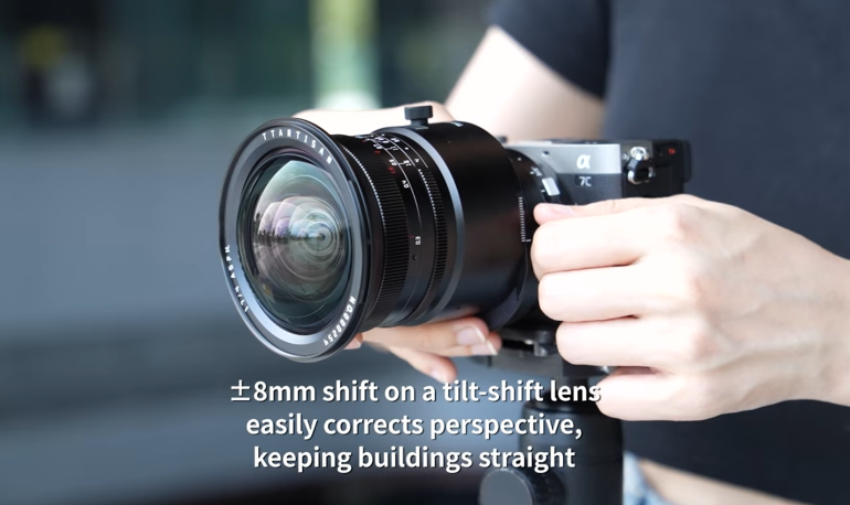 Person holding a camera with a tilt-shift lens; text explains ±8mm shift helps keep buildings straight.