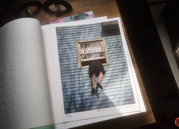 A photo in an open book shows a person climbing through a window of a blue house, legs dangling outside.