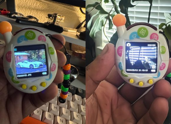 Close-up of a hand holding a digital toy displaying car images on its small screen, with plants in the background.