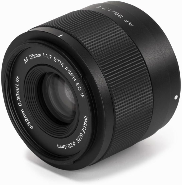 A black 35mm camera lens with focus and aperture markings visible on the side and rim.