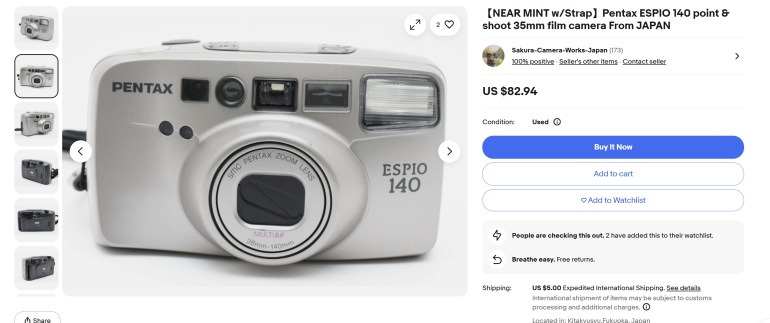 Silver Pentax Espio 140 film camera with lens and viewfinder, shown in an online sales listing.