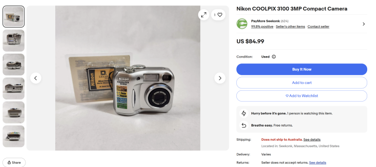 A silver Nikon COOLPIX 3100 digital camera with a Lexar 256MB memory card on a white background.