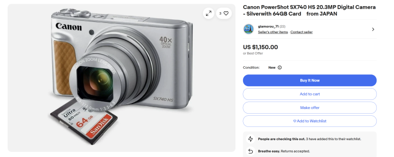 Silver Canon PowerShot SX740 HS camera with a 64GB SanDisk SD card shown on a white background.