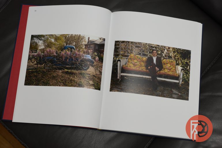 An open photo book showing a blue truck with flowers and a man sitting on a floral couch outside.