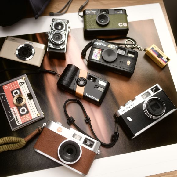 A collection of various vintage and retro-style cameras arranged on a table.