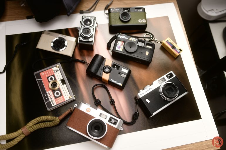A collection of various vintage and retro-style cameras arranged on a table.