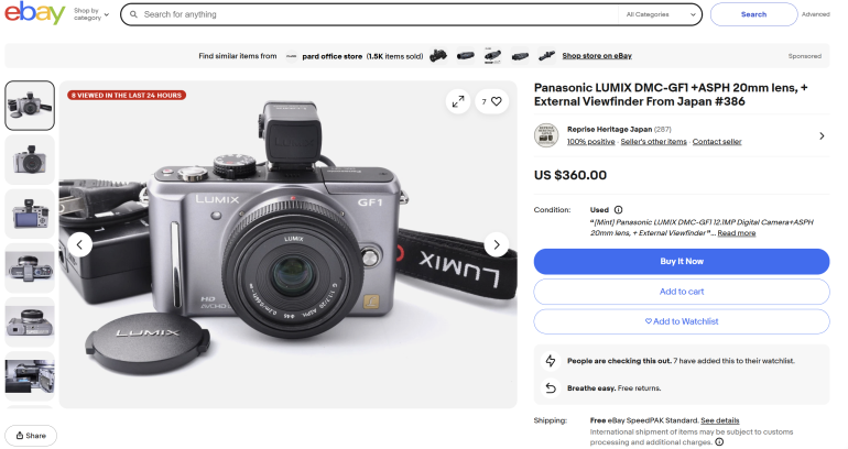 Panasonic LUMIX DMC-GF1 camera with 20mm lens, viewfinder, and cap displayed on an eBay product listing page.