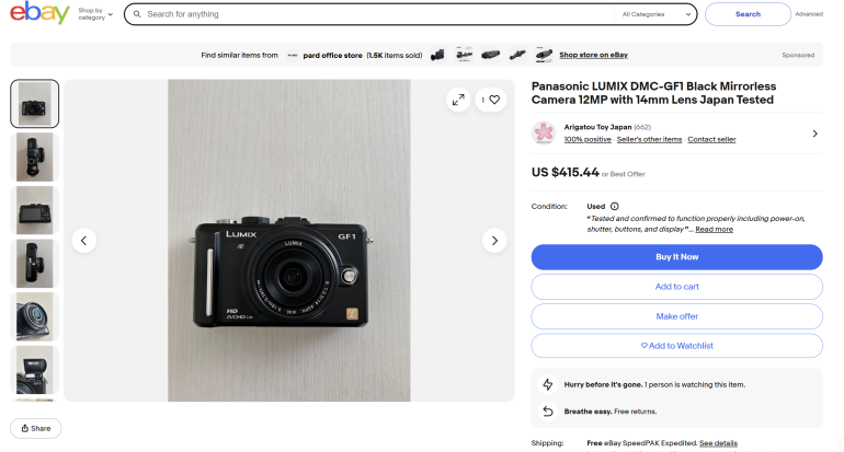 Panasonic LUMIX DMC-GF1 mirrorless camera with 14mm lens displayed on a light-colored surface.