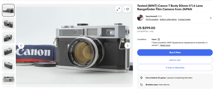 Canon 7 rangefinder camera with 50mm lens, strap, and lens cap on a white surface, listed for sale online.