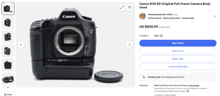 Canon EOS 5D camera body without lens, battery grip attached, and lens cap shown on a white background.