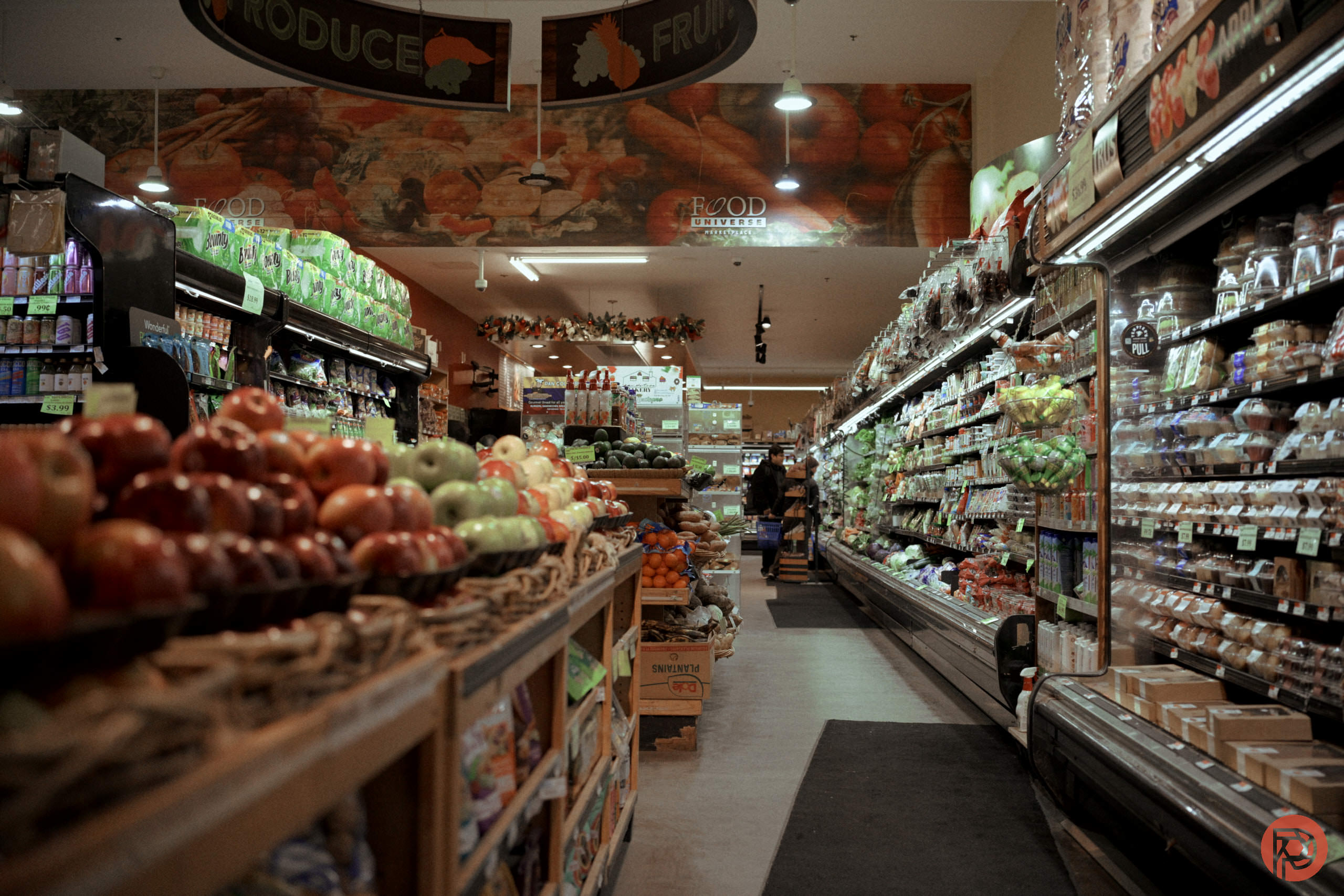 I Did a $324K Shoot for a Grocery Store A grocery store aisle with produce on the left and refrigerated items on the right. Shoppers are in the background.