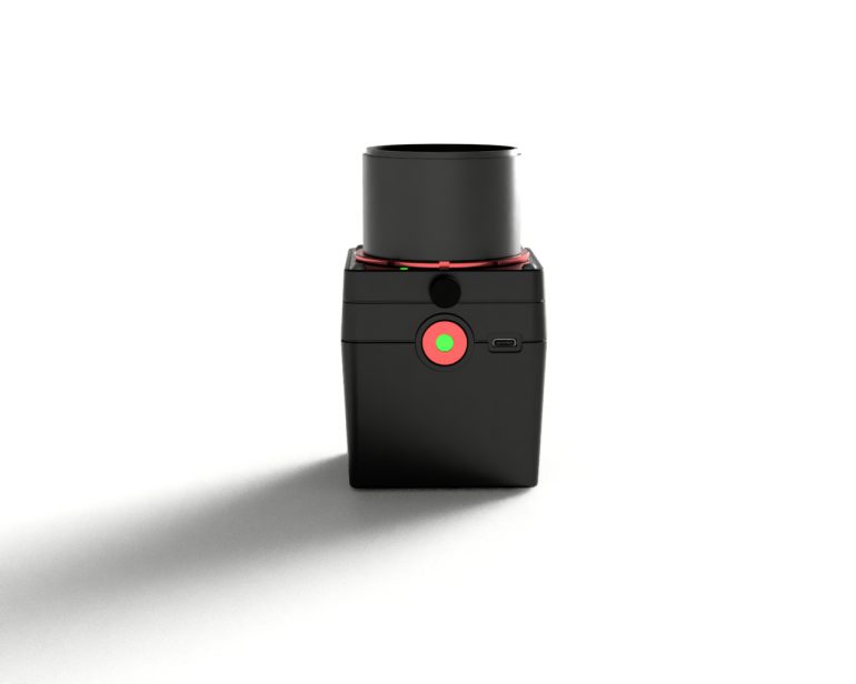 A black, box-shaped electronic device with a large button and a cylindrical top, on a white background.