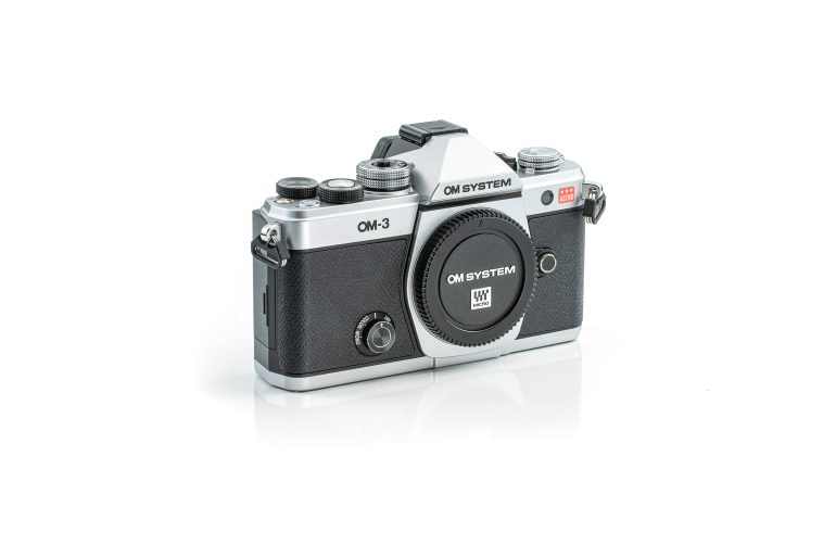 A black and silver OM System OM-3 film camera on a white background.