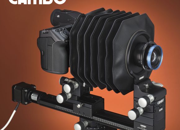 A large format camera setup with a bellows and digital camera back, shown against a red background.
