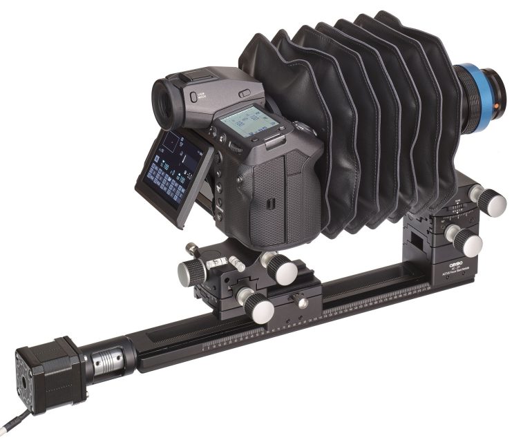 Digital camera with a bellows attachment mounted on a rail system for precise macro or technical photography.