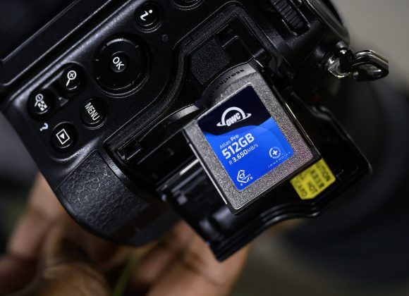 Close-up of a camera with a 512GB memory card partially inserted in the memory card slot.