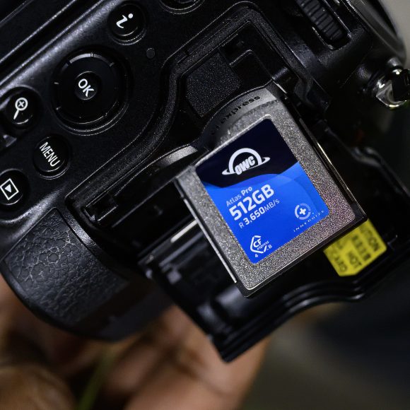 Close-up of a camera with a 512GB memory card partially inserted in the memory card slot.