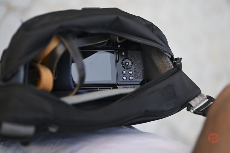 A digital camera inside an open black bag, viewed from above.