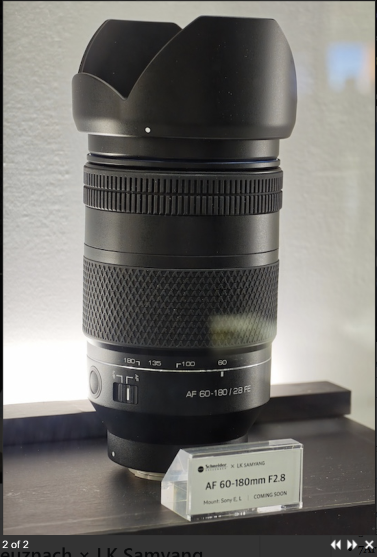A Samyang AF 60-180mm F2.8 camera lens on display with a label indicating it is coming soon.