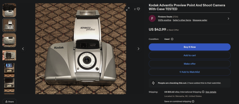 Kodak Advantix Preview silver camera with case displayed on a patterned brown carpet, listed for sale online.