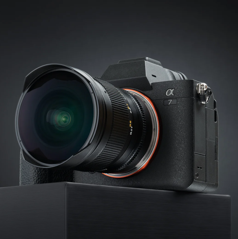 A black Sony Alpha 7 camera with a wide-angle lens, displayed on a dark platform against a dark background.