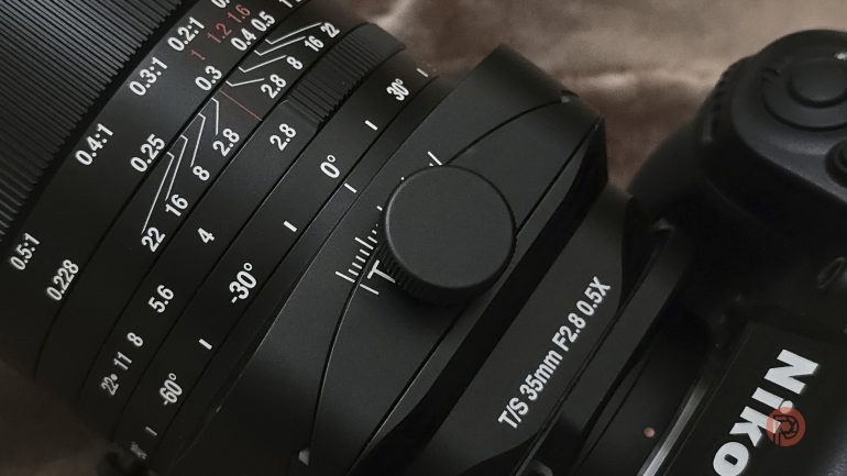 Close-up of a Nikon camera with a T/S 35mm F2.8 lens showing focus and tilt/shift adjustment rings.