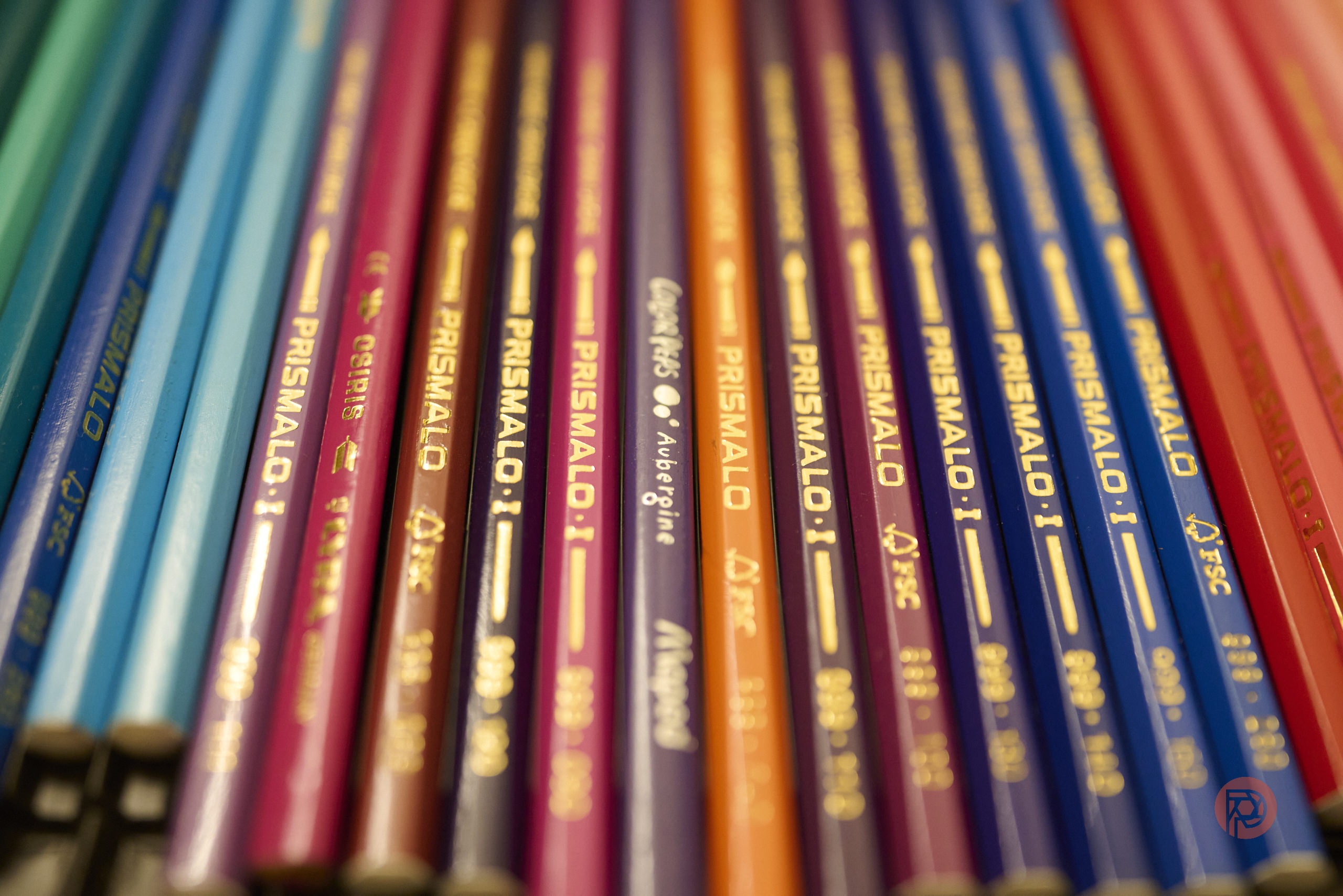 Close-up of colorful Prismalo colored pencils arranged side by side, showing their labels and vibrant hues.