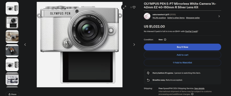 Silver Olympus PEN E-P7 mirrorless camera with lens and flip-down LCD screen displayed on an online store page.