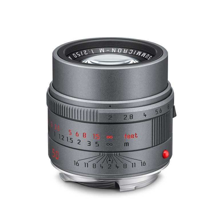 A silver camera lens with engraved numbers and markings for aperture and focus distance.