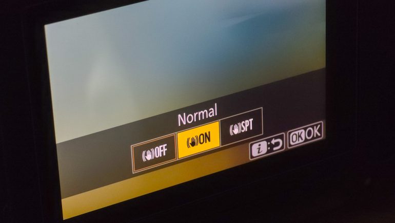 Camera screen showing a Normal setting with OFF, ON, and SPT options. ON is highlighted in yellow.