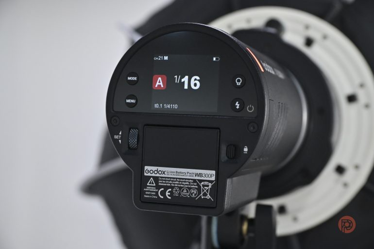 Close-up of a Godox camera flash unit display showing settings and controls.