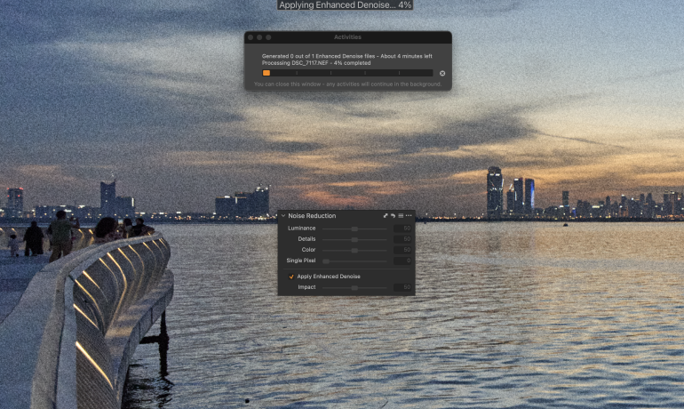 Photo editing software shows enhanced denoise applied to a grainy city waterfront image at sunset.