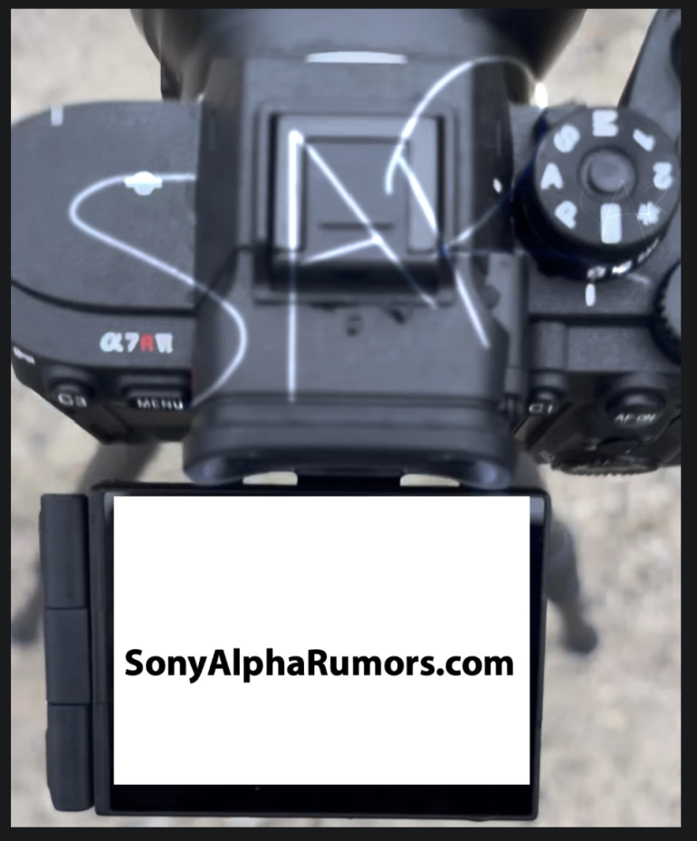 Top view of a Sony Alpha camera with its LCD screen displaying SonyAlphaRumors.com in black text.
