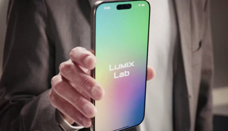 A person holds a smartphone displaying a colorful screen with the text LUMIX Lab.