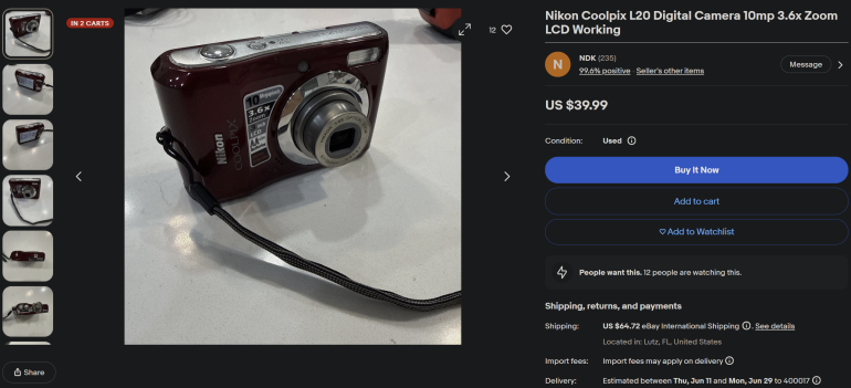 Red Nikon Coolpix L20 digital camera with wrist strap displayed on a white surface.
