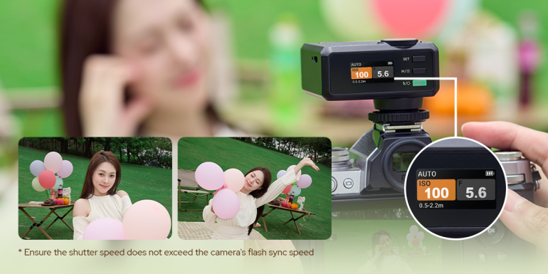 A digital camera displays ISO 100, 1/50s, f/5.6 while photographing a woman holding pink balloons outdoors.