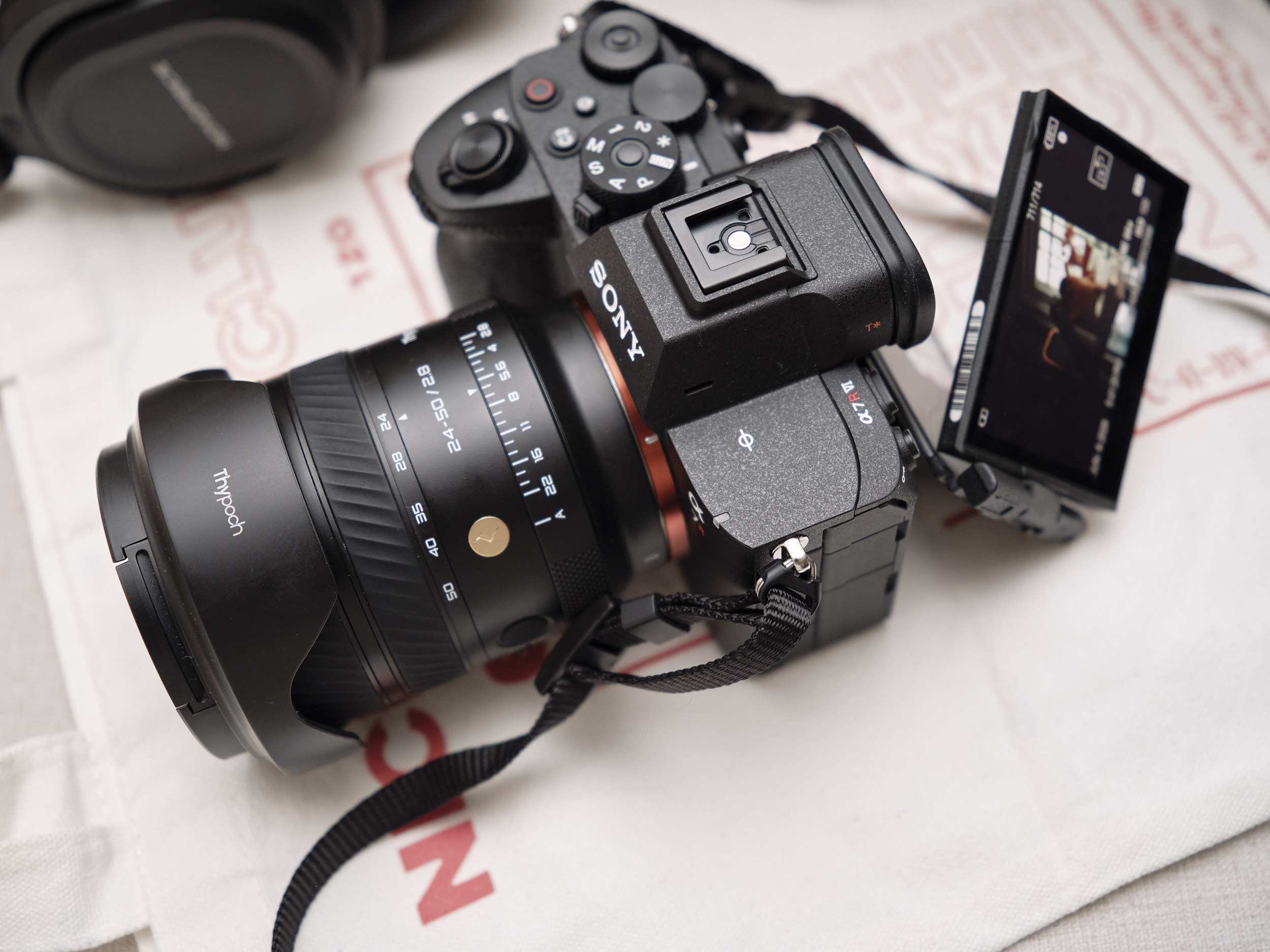Sony a7RVI Review Update: Is this Camera Really That Special? A Sony camera with a large lens and flip-out screen displaying a photo, resting on a white surface.