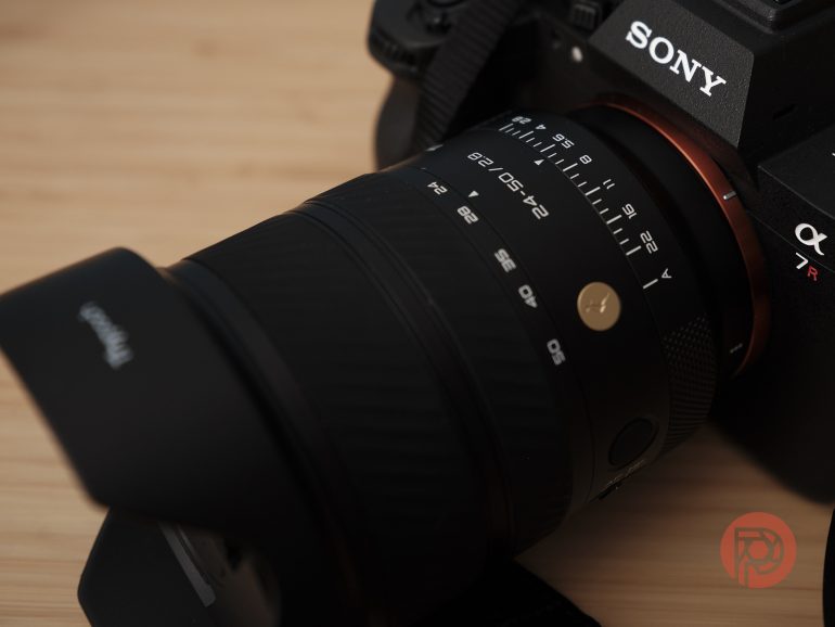 Close-up of a Sony Alpha 7R camera with attached lens, showing focus and aperture markings.