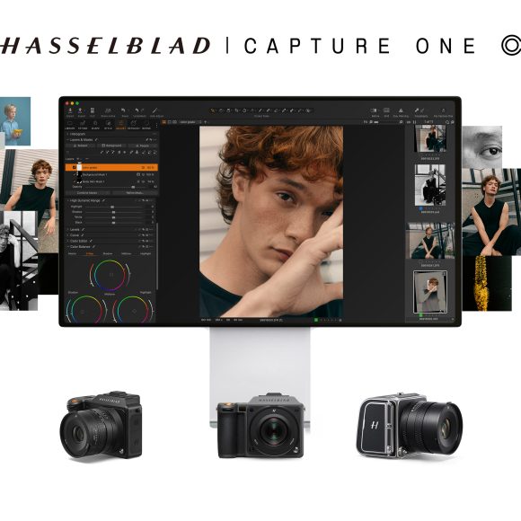 A computer screen displays a portrait editing software, surrounded by Hasselblad cameras and various portrait photos.