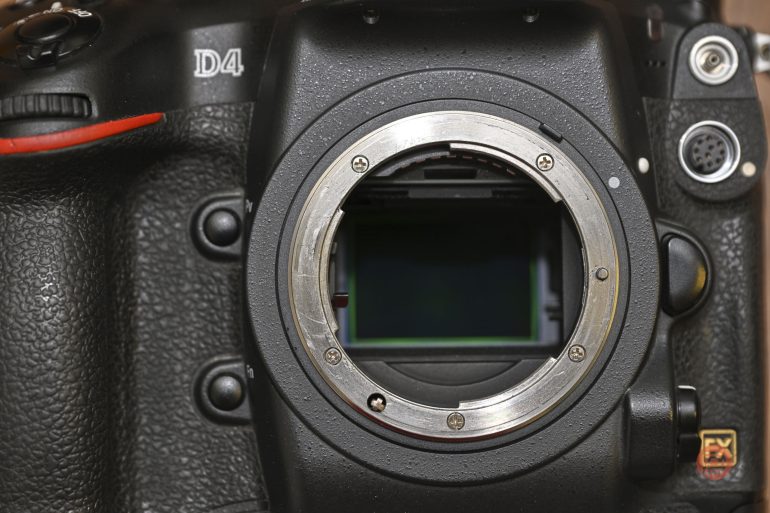 Close-up of a Nikon D4 camera body showing the lens mount and exposed image sensor.