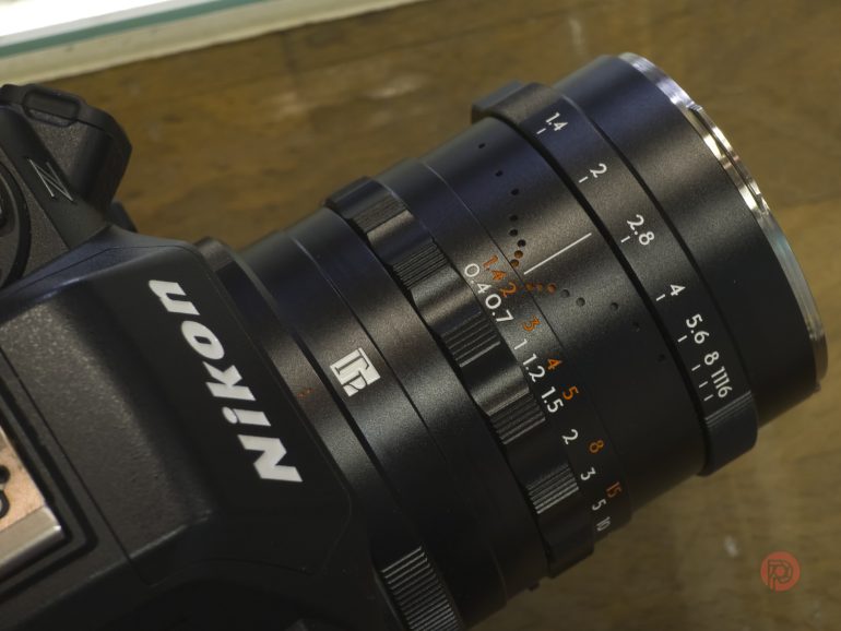 Close-up of a Nikon camera with a manual focus lens showing aperture and focus distance markings.