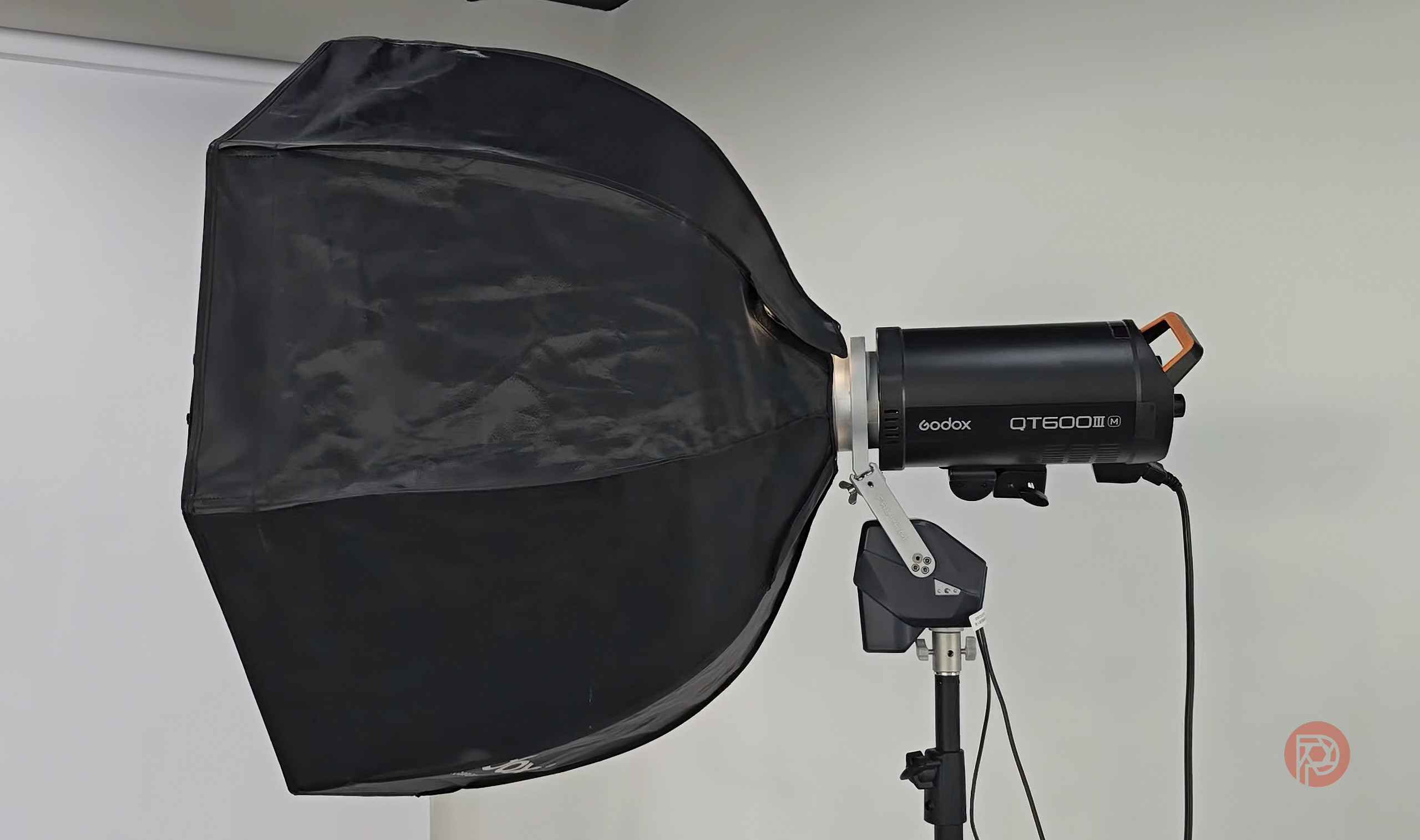 Does the Ulanzi Falcam Move LightGo Replace Photo Assistants? A black Godox QT600II flash with a large octagonal softbox on a light stand in a studio setting.